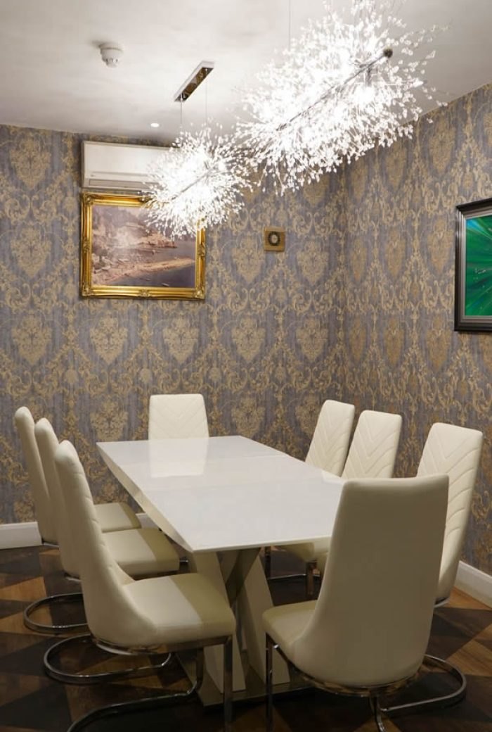 The private room: a white table for ten under crystal chandeliers, with damask walls